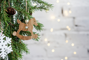 A wooden decoration hangs on a Christmas tree branch